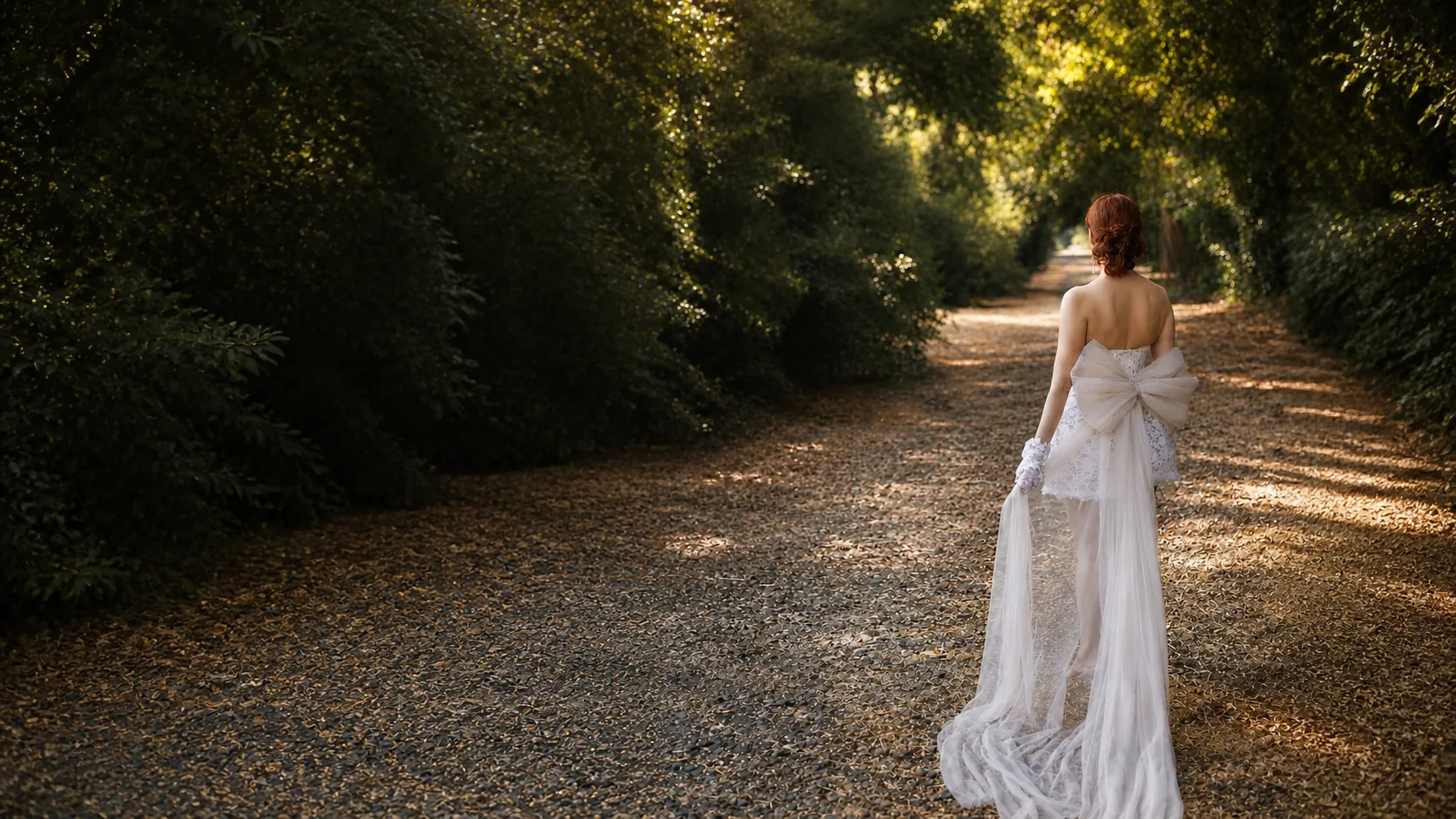 A DORDO bride walking along a sunlit garden path in a sculptural ivory dress